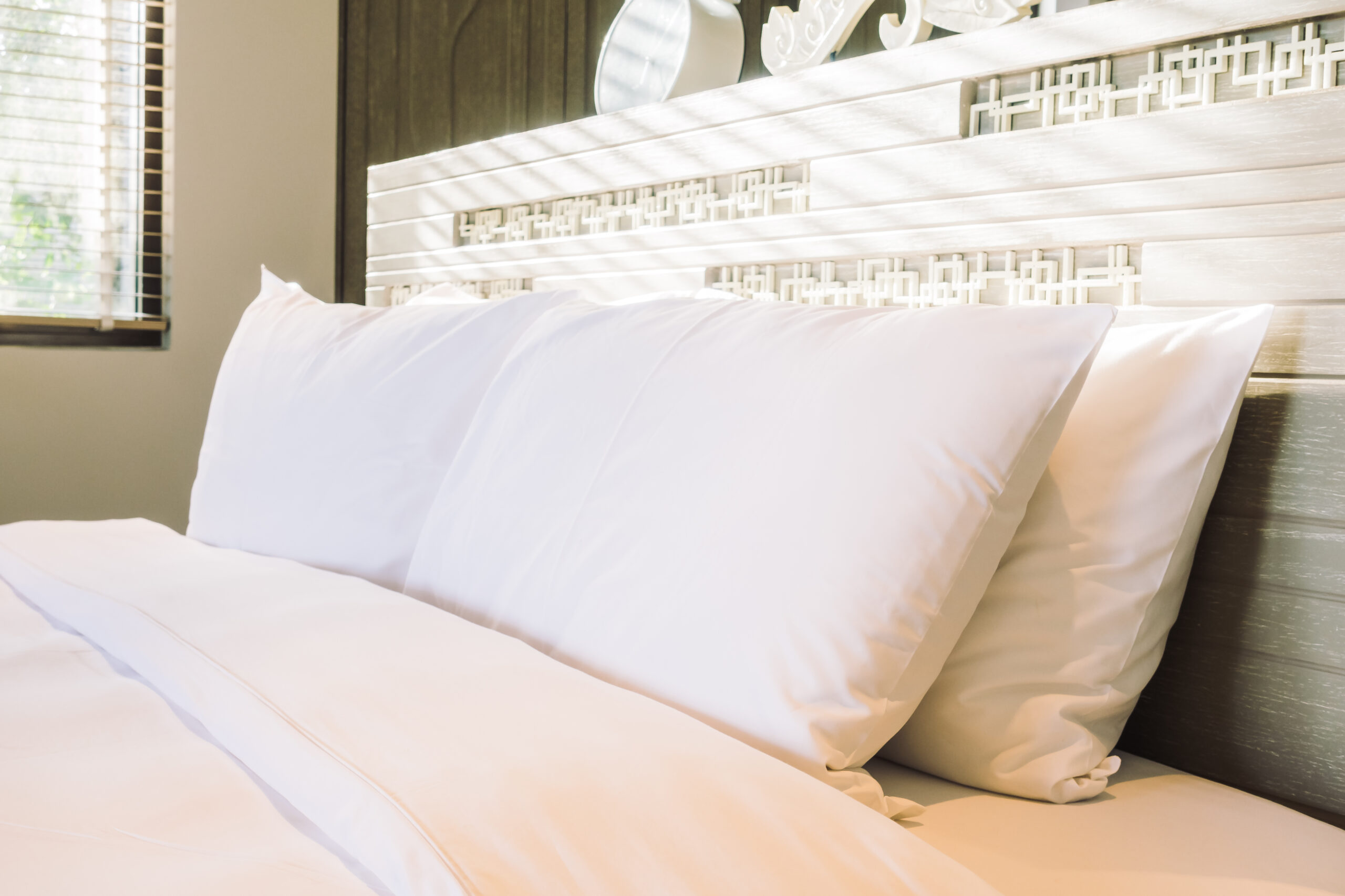 Beautiful white pillow on bed decoration in bedroom interior - Vintage light Filter